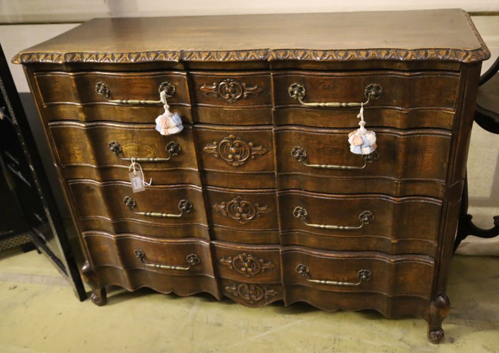 A 20th century French oak commode, fitted four long drawers with carved decoration, width 122cm, depth 43cm, height 92cm